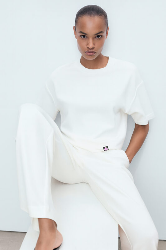 RahRaha Hustle White T-Shirt for Women – Front view oversized relaxed fit with purple logo tag
