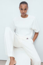 RahRaha Relentless White T-Shirt for Women – Editorial sitting pose showcasing relaxed fit