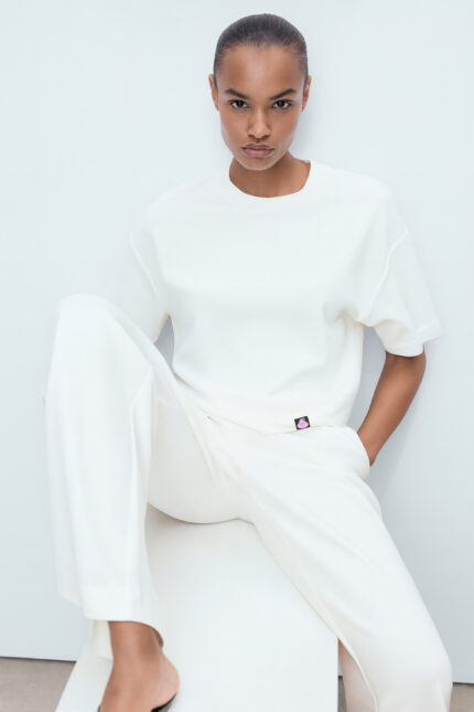 RahRaha Relentless White T-Shirt for Women – Editorial sitting pose showcasing relaxed fit